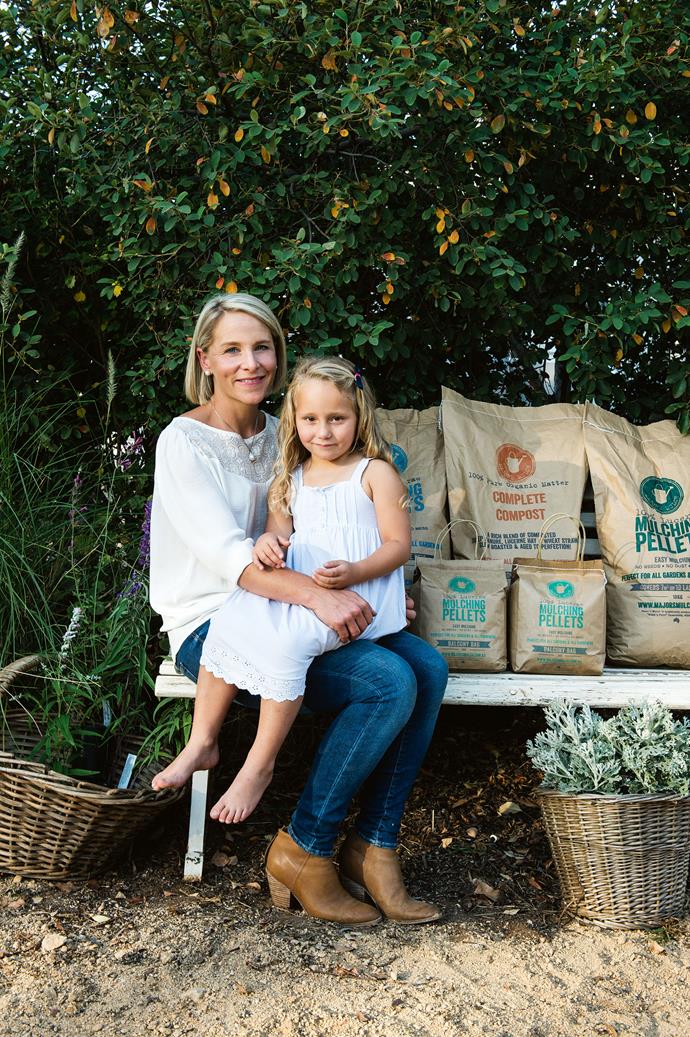 Mum and daughter next to a range of Major's Mulch products. All of the products are packaged in recyclable bags.