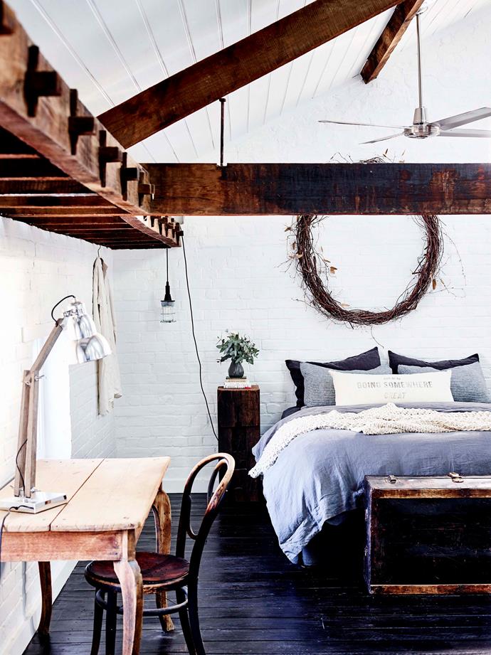 Exposed ironbark mortice-and-tenon beams feature in the main bedroom. The hanging light is from Tomolly.