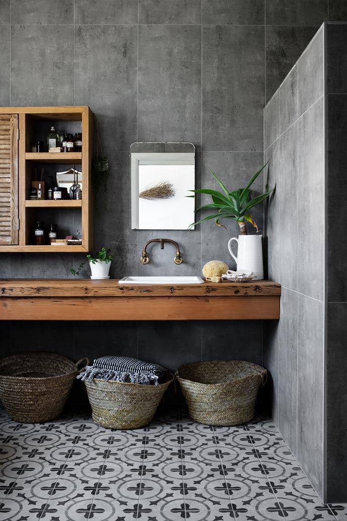 A slab of recycled Oregon timber provides plenty of bench space in this [newly built home on Lake Conjola](https://www.homestolove.com.au/modern-barn-style-house-19961|target="_blank"), NSW. An [inset sink from IKEA](https://www.ikea.com/au/en/p/havsen-inset-sink-1-bowl-white-s29253775/|target="_blank"|rel="nofollow") was installed to maintain the lines of the timber bench. Copper tapware and a timber storage cabinet offset the cool tones in the concrete-look tiles.
