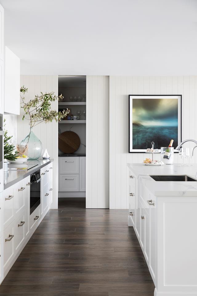 Lining boards on the walls in this kitchen add to the [Hamptons vibe](https://www.homestolove.com.au/modern-hamptons-home-sydney-19531|target="_blank"), while the sliding-door pantry offers discreet functionality.