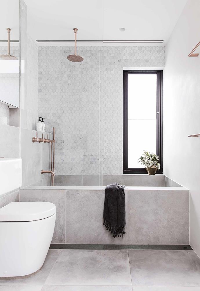 A small but deep bath was built in the upstairs bathroom [of this renovated Queens Park cottage](https://www.homestolove.com.au/federation-cottage-queens-park-18311|target="_blank") using large format grey tiles. Rose-gold tapware adds warmth to the space. *Design: [Alexander&Co](https://alexanderand.co/|target="_blank"|rel="nofollow") | Build: [Fairweather Building](http://www.fairweatherconstructions.com/|target="_blank"|rel="nofollow") | Styling: Vanessa Colyer Tay | Photography: Maree Homer*.