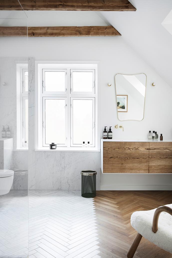 The bathroom, with its marble and timber floor, is Pernille's favourite room in the house; the family often hangs out here when Billy has his bath. The mirror is Gubi and the chair is by Philip Arctander.