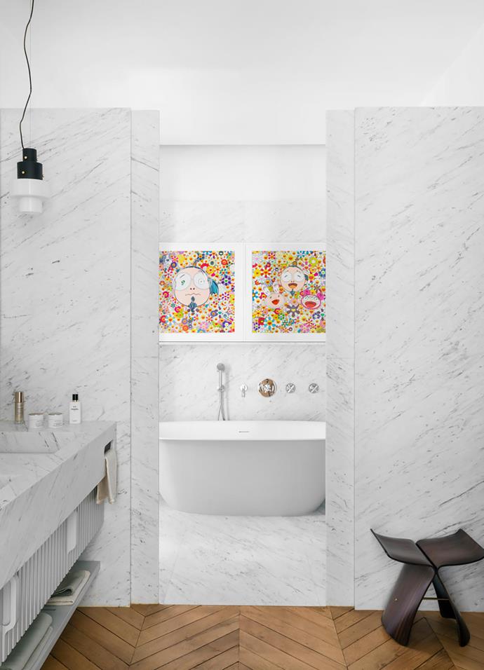 The main bathroom is clad in Carrara marble. 'Butterfly' stool by Sori Yanagi. Beta Essential bath from Hidrobox. The two screenprints are by Takashi Murakami. 'Roma' tap and bath fixtures from Stella.