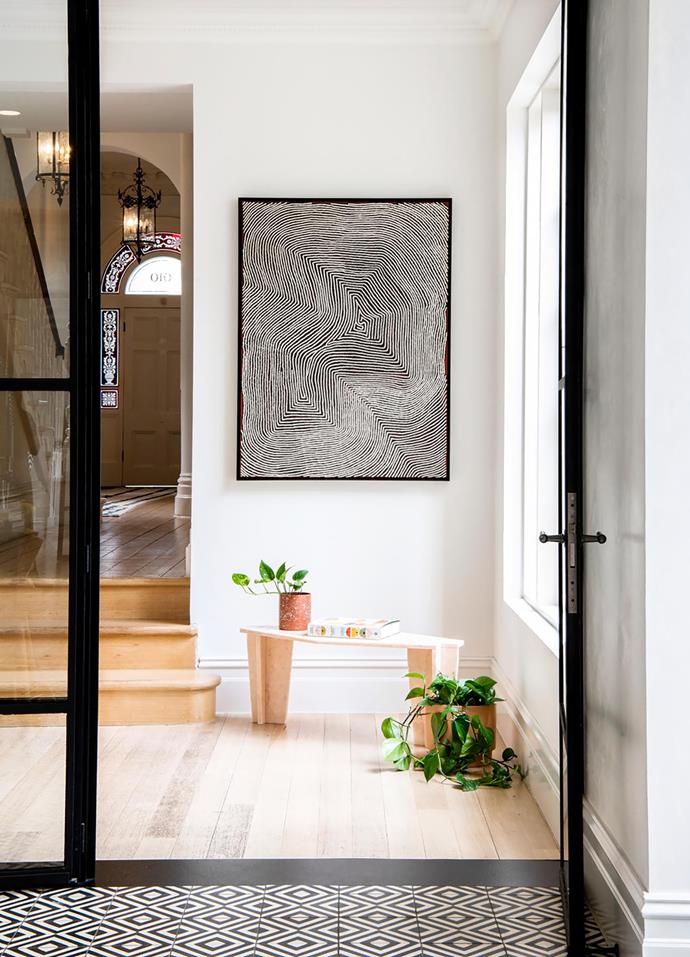 In the hallway under a work by Warlimpirrnga Tjapaltjarri is an Italian marble table sourced by Simone. Ceramics from Modern Times and Pépite sit on the table by Studio Thomas Lentini.
