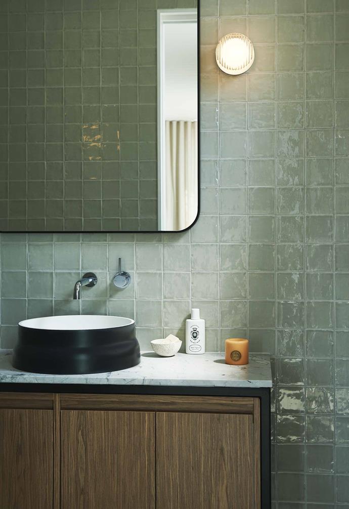 **Cool change** Textural wall tiles create a sense of serenity to the bathroom, designed by Tom Mark Henry Studio. Encased in timber and marble, the vanity unit plays with different natural materials. *Photography: Damian Bennett*.