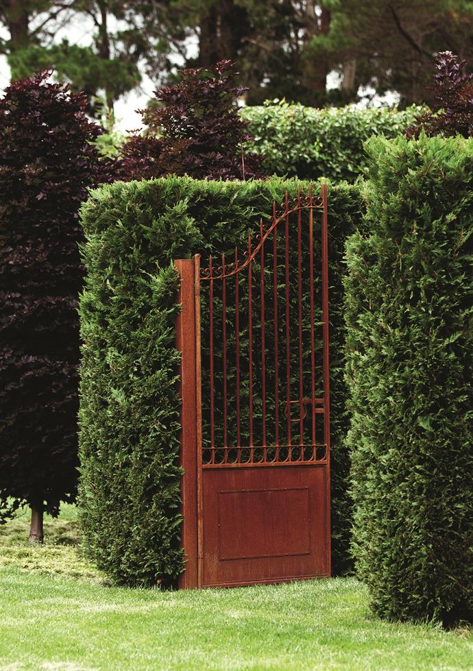 Tall iron gates with a rust finish were custom made for the garden.