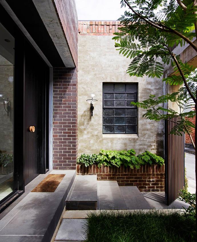 Architects Kerry Phelan and Stephen Javens, directors of K.P.D.O., created a home out of the ramshackle garage of an old military building in Melbourne. The entrance to the property features a small courtyard hidden behind a dark timber gate. *Photograph*: Richard Powers. From *Belle* June/July 2016.