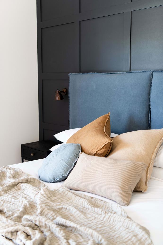 A comfy stack of linen throw cushions adorn the bed.
