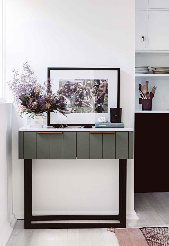 **Jillian**: For a small kitchen, there is a lot of storage. Everything can be put away and kept off the benchtop, which is absolutely key for maximising limited workspace! <br><br>**Entry** As soon as you open the front door, this vignette greets you. "The entry table was topped with spare kitchen benchtop material, Quantum Quartz surface in Statuario Quartz," says interior designer Jillian. The cabinet also features MadeMeasure leather pulls. Photograph by Benny Horne for Vogue Australia.