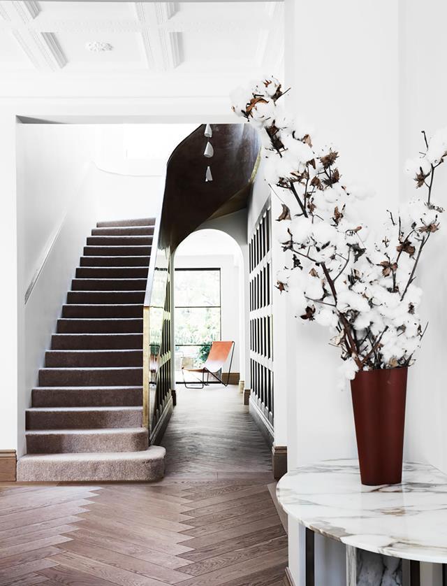 The stairwell is the central spine of this home designed by Alwill Interiors and Luigi Rosselli Architects and is finished in white and putty-coloured stucco lustre with a handcrafted brass rail and natural alpaca carpet. From *Belle* June/July 2019.