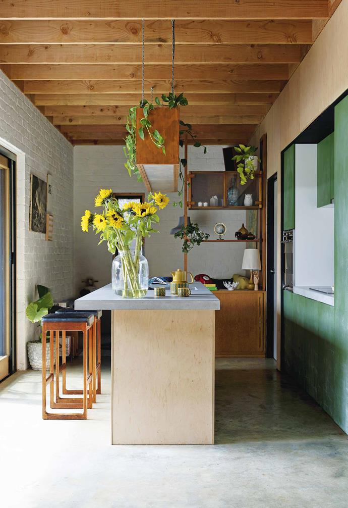 On the ground floor of this [compact eco-friendly home](https://www.homestolove.com.au/small-eco-friendly-house-19983|target="_blank") timber exposed beams add warmth to the polished concrete floor and painted brick walls.