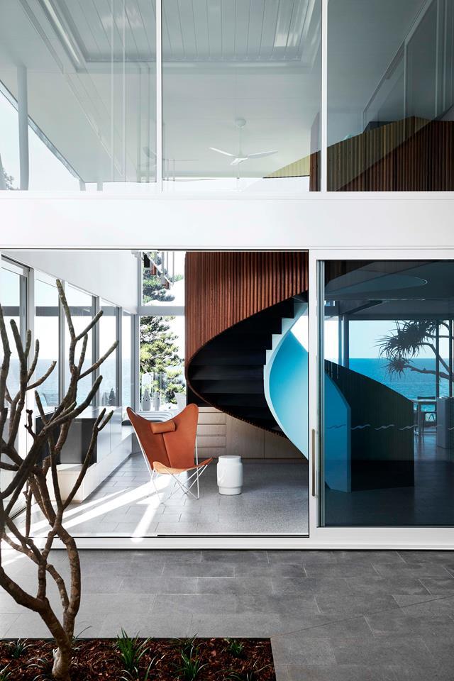 Whispers of Palm Springs, a marine palette and an oceanic outlook make for a [breezy beach retreat](https://www.homestolove.com.au/palm-springs-style-beach-house-19258|target="_blank") designed by PopovBass Architects. A tan leather **'Butterfly' chair** sits next to the spiral staircase. From *Belle* November 2018.