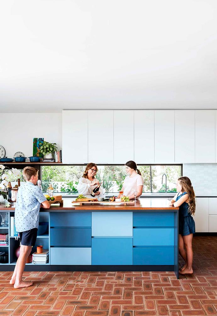 When we think about exposed brick in the home we often think about retained walls from the house's heritage past. In this [striking family home in Perth](https://www.homestolove.com.au/sloping-corner-block-house-design-19523|target="_blank"), herringbone [brick flooring](https://www.homestolove.com.au/the-ultimate-guide-on-buying-the-right-flooring-for-your-home-15866|target="_blank") runs throughout the open-plan kitchen and living space, creating a warm visual  contrast to variegated blue, white and black kitchen cabinetry.