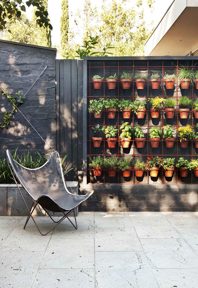 By stacking these various herb pots, this outdoor area conserves ample space.