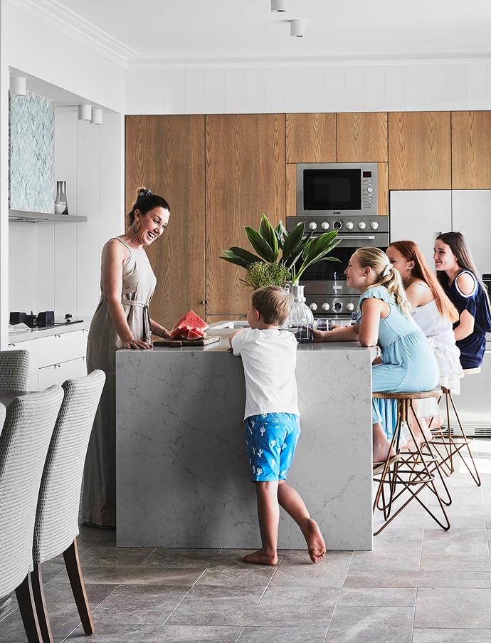 Space to congregate, low-maintenance surfaces and plenty of storage were essential ingredients in the kitchen since it needed to cater for such a large extended family, including (from left) Fred, Ava, Zoe and Alex. Thanks to its northerly orientation and elevated position, the room receives plenty of natural light year round, enhancing the relaxed holiday vibe. Joinery by Platinum Detailed Joinery.