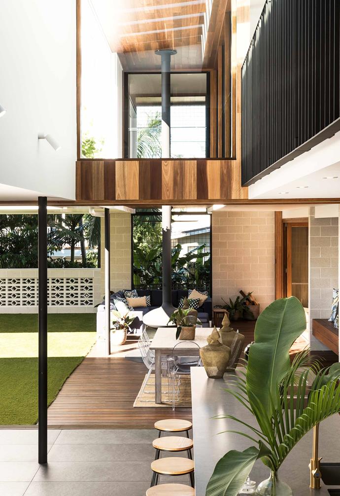 This contemporary home features an outdoor room that connects seamlessly to the open-plan living area. Encasing the balcony are breeze blocks that create an interesting visual element to the space.