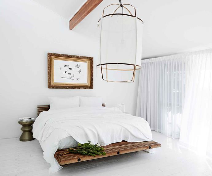 Clean, all-white bedroom with oversized linen pendant