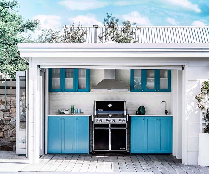 Weber barbecue in a blue outdoor kitchen