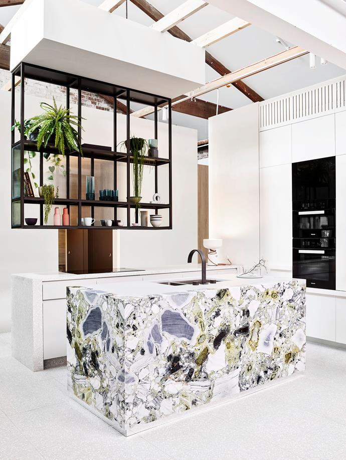 SJB senior interior designer Charlotte Wilson clad an island bench in expressive stone and suspended slimline shelving above for this dramatic kitchen design where sleek appliances play a discreet supporting act. Mint Green marble from Euromarble.