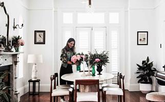 Woman arranging flowers on dining table