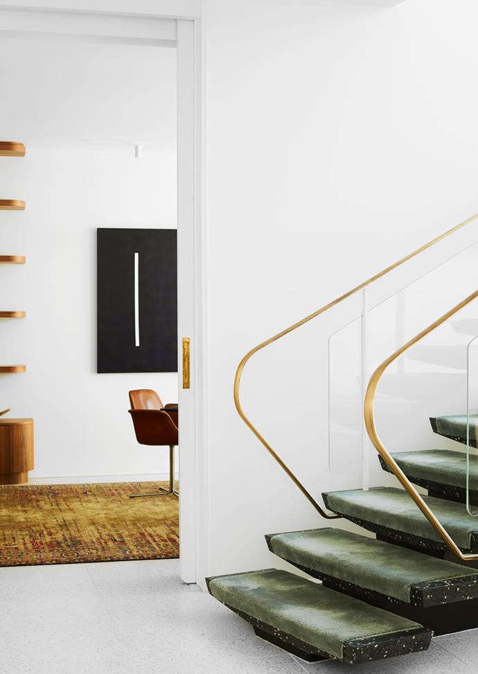 A view across the central void. The artwork beyond is by the owner's father. The cantilevered switchback staircase was retained but with a brass and glass balustrade and a carpet runner from Whitecliffe Imports added.