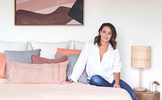 Michelle Bridges sitting on a pink bed