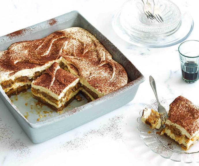 Tiramisu in a tray with a slice on a plate