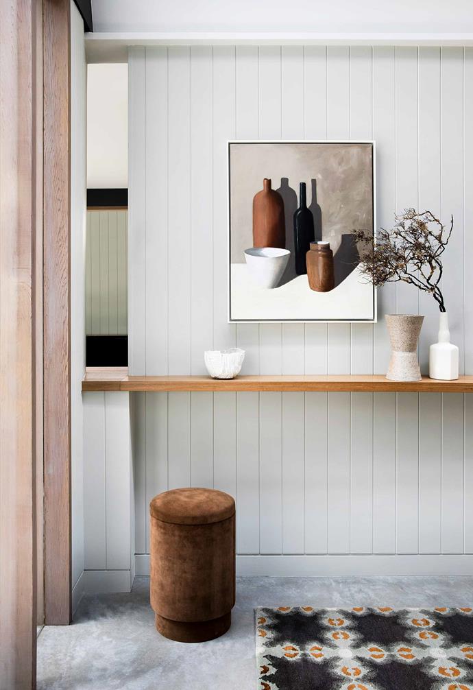 A statement artwork welcomes you inside this [nature-inspired home in Riverview](https://www.homestolove.com.au/nature-inspired-house-riverview-20198|target="_blank") and echoes the warm colour palette that runs throughout the house. A floating shelf in the entryway provides the perfect space for displaying objects and is paired with a patterned rug.