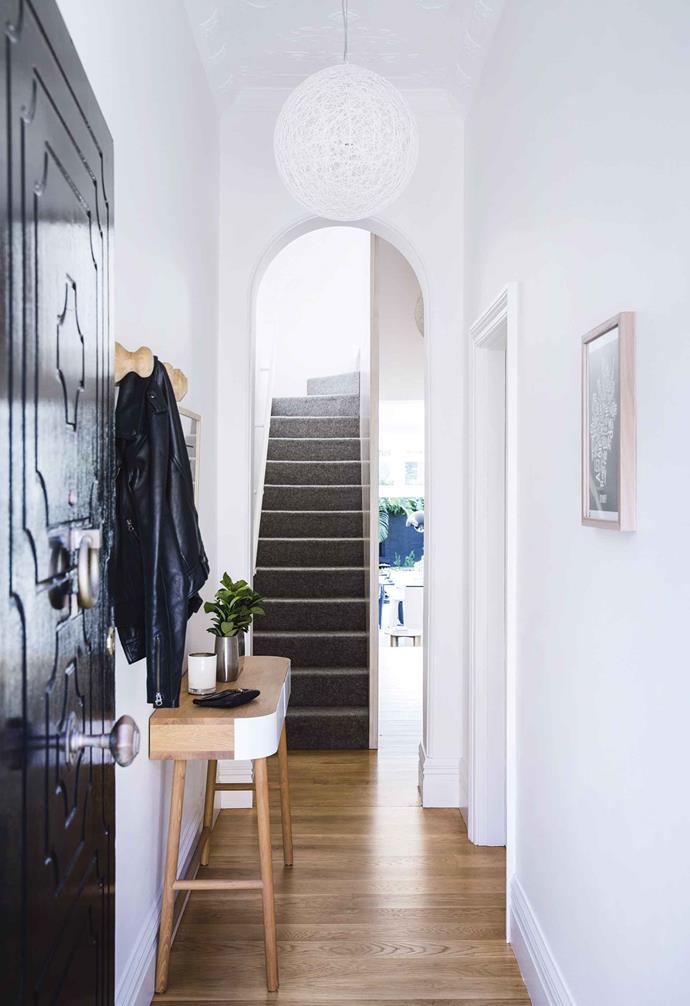 A simple timber hallway console is paired with timber wall hooks and a white woven pendant light welcome you inside this [relaxed Paddington terrace](https://www.homestolove.com.au/relaxed-terrace-paddington-18366|target="_blank"). 