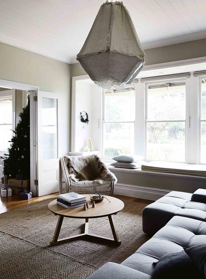 Natural textures and a muted colour palette in the sitting room, with a 'Cumulus' pendant light by Enoki and 'Swing Chair' by Stefan Heiliger, both from Curious Grace in Melbourne.