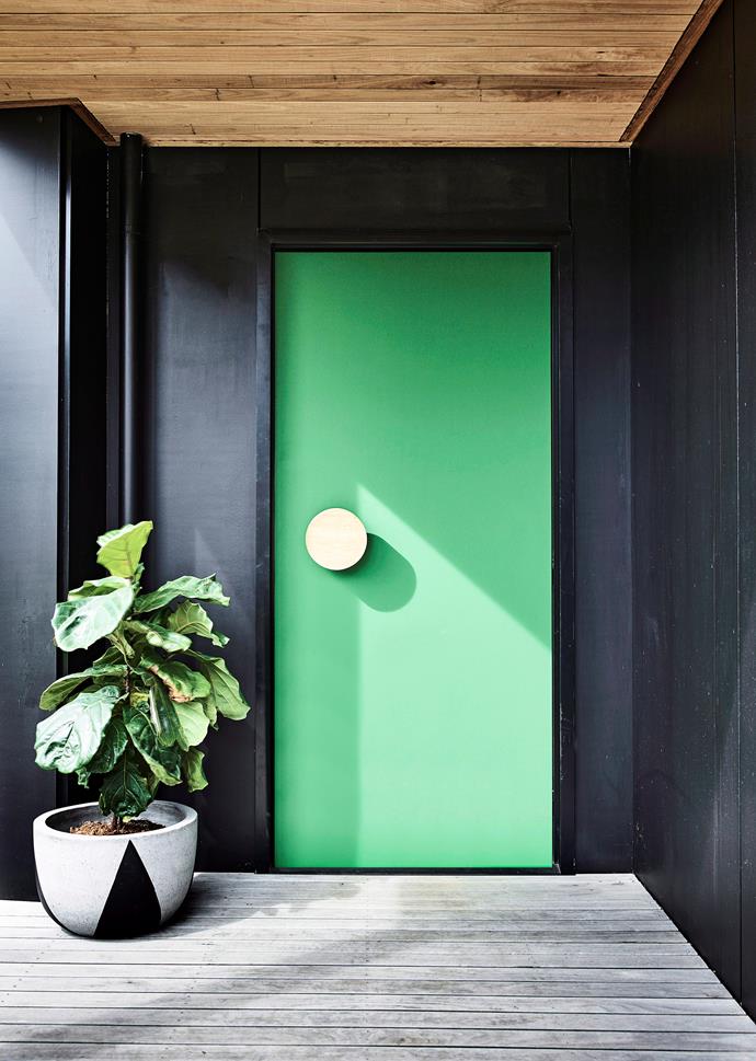 A bright green front door and a lush fiddle-leaf fig create a warm and happy welcome.