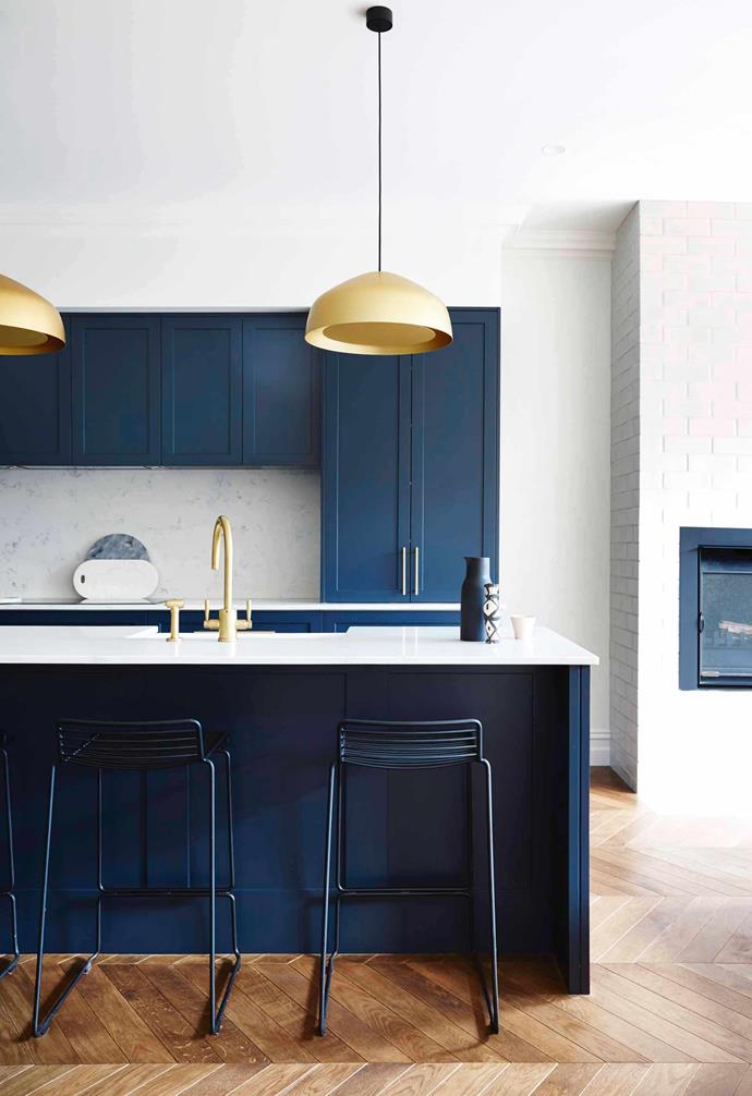 In this [renovated Edwardian semi](https://www.homestolove.com.au/modern-edwardian-semi-renovation-18524|target="_blank") blue kitchen cabinets add a modern touch to the heart of the home. The shaker profile of the cupboards lend a classic look to the space, with gold tapware and pendant lights adding a glamourous touch. 