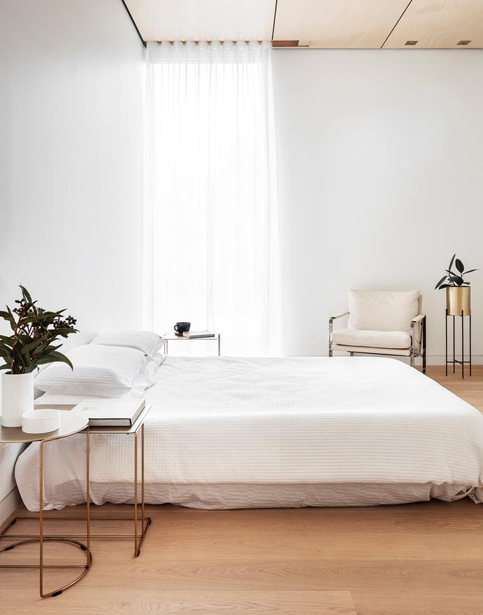 This calming sleep space features Walter Knoll 'Oki' brass tables and 'Fabricius' armchair, all Living Edge. Silent Gliss automated curtain track from Oz Shade
