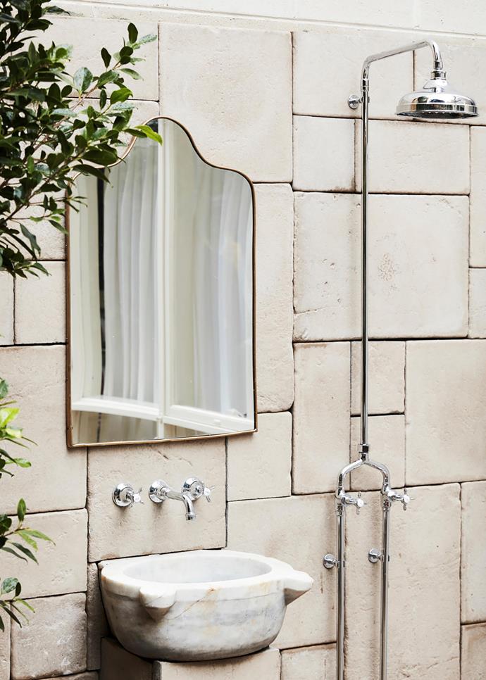 This sun-lit alfresco shower is paved with French sandstone and fitted out with Astra Walker tapware, a Gio Ponti mirror and a Moroccan marble basin.