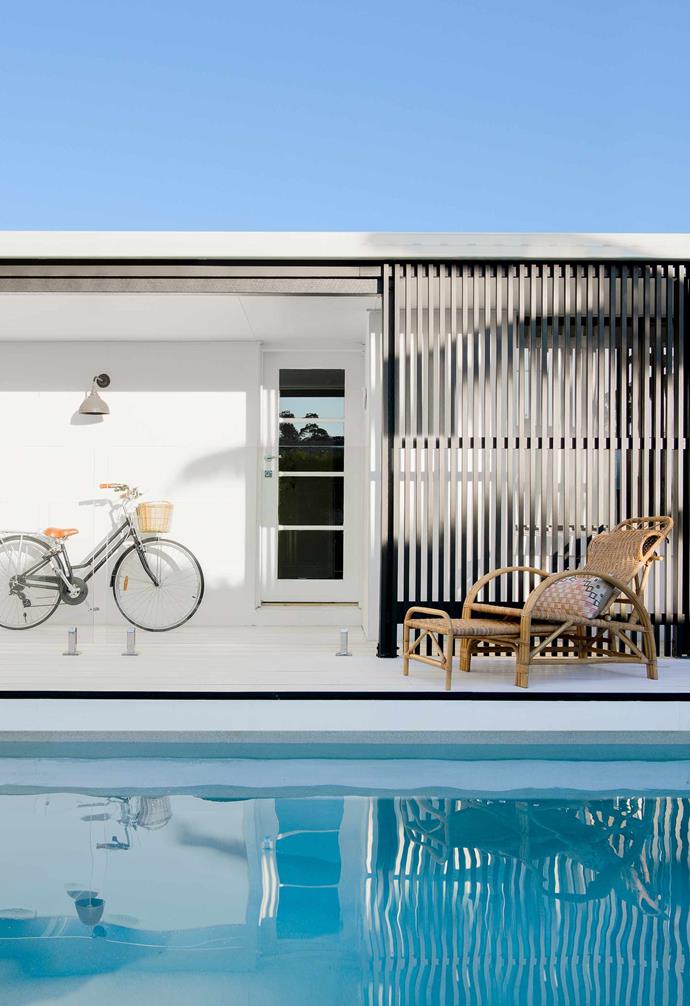 A stark monochromatic palette and strong linear presence is offset by the warm rattan timber chair and crystal blue pool in this [chic Mooloolaba beach house](https://www.homestolove.com.au/beach-house-mooloolaba-21069|target="_blank").