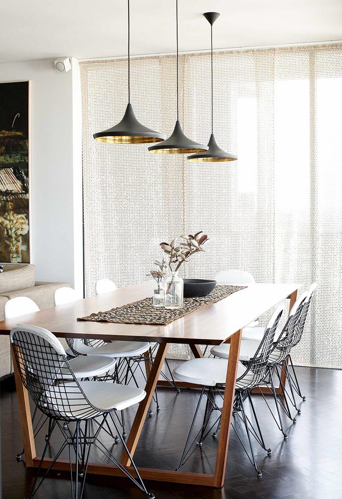 The modern and sophisticated dining area of [Fiona Lyda's chic apartment](https://www.homestolove.com.au/fiona-lyda-apartment-16883|target="_blank") features Tom Dixon 'Beat' pendant lights, 'Fineline' dining table and 'Eiffel' chairs from Spence & Lyda. Sunlight through the huge windows is screened by Missoni Home 'Jalpa' fabric.
