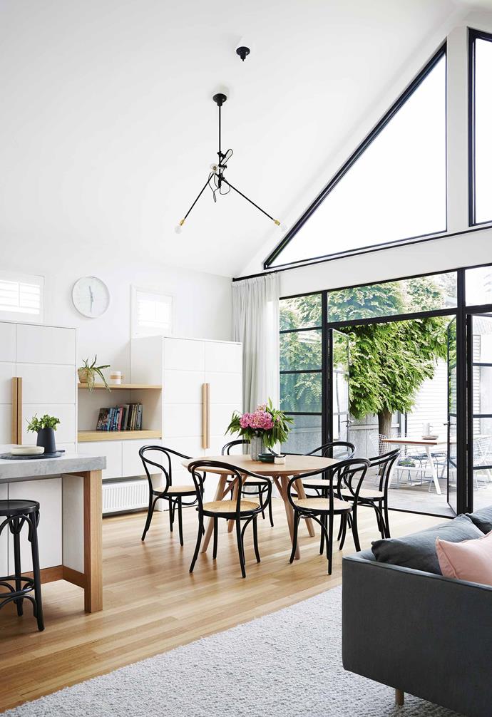 In an open-plan room choosing a circular dining table is a clever choice as they do not obstruct movement around the space. In this [Scandi-style home](https://www.homestolove.com.au/scandi-style-glass-house-extension-17515|target="_blank") the timber dining table is matched with striking sculptural black-and-rattan dining chairs. 