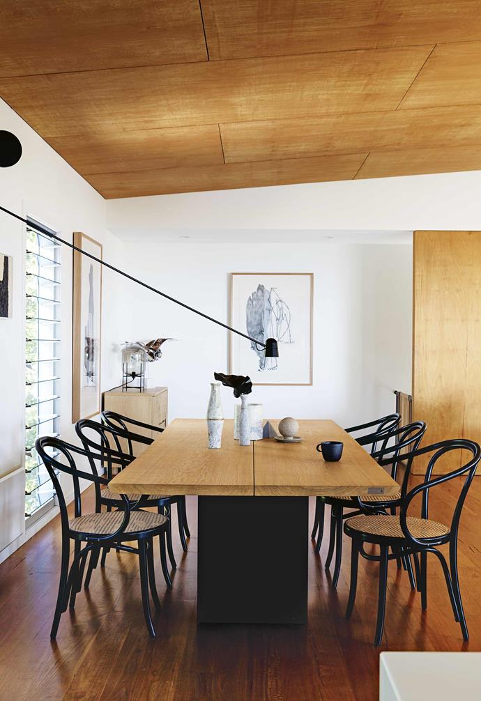 The angled hoop-pin panelled ceiling in the dining room of this [luxurious beach house in Macmaster's Beach](https://www.homestolove.com.au/macmasters-beach-house-18226|target="_blank") transforms the dining area into a cosy nook within the home. Complementing the liberal use of timber tones throughout the home, the timber-topped table is paired with bent wood and rattan dining chairs. 
