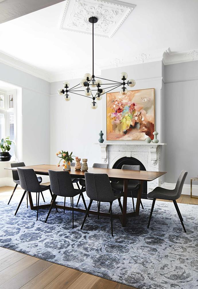 After the addition of a striking [contemporary extension to this century-old Edwardian home](https://www.homestolove.com.au/a-modern-extension-revived-this-century-old-edwardian-home-7147|target="_blank"), this family had ample space to play with. In this generous dining room, a large rug adds a sense of grandeur where a timber dining table and original fireplace take pride of place.