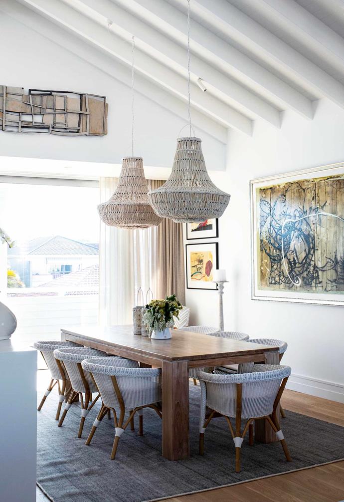 Former Australian Women's Weekly editor [Deborah Hutton transformed her Bronte home into a Hamptons-style haven](https://www.homestolove.com.au/deborah-huttons-hamptons-inspired-renovation-14043|target="_blank"). In the dining room she has paired white woven chairs with rattan pendant lights that hang from pitched white exposed ceiling beams.