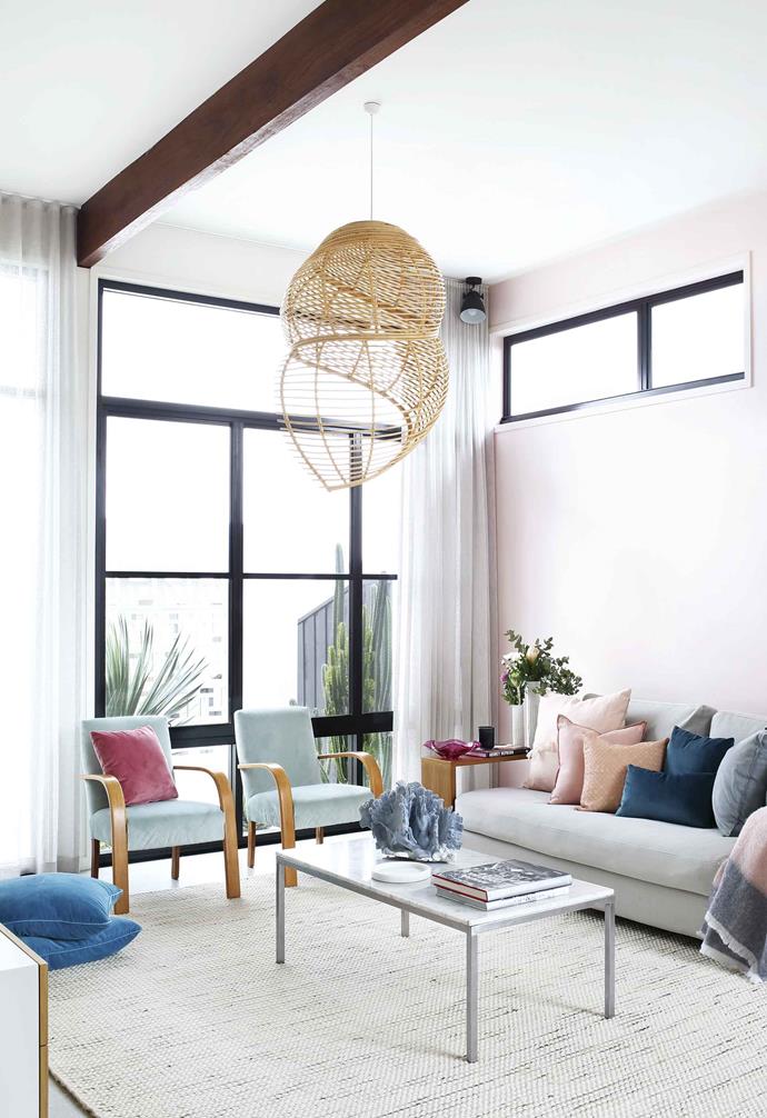 The pink feature wall in the living room of this [Palm Springs-style home in Casuarina](https://www.homestolove.com.au/palm-springs-mid-century-casuarina-18340|target="_blank") provides a subtle contrast to the white ceiling and walls, while maximising the ample natural light that floods into the space.