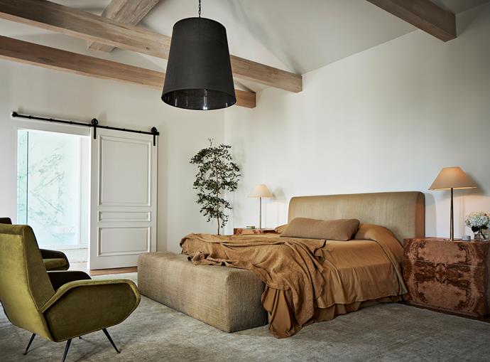 Jase custom designed the master bed and base as well as the burl bedside tables. 1960s green velvet armchairs sourced from Hollywood at Home and the Hans-Agne Jakobsson table lamps from Rewire. Ochre-hued Matteo bed linens and a vintage rug from Jamal's.