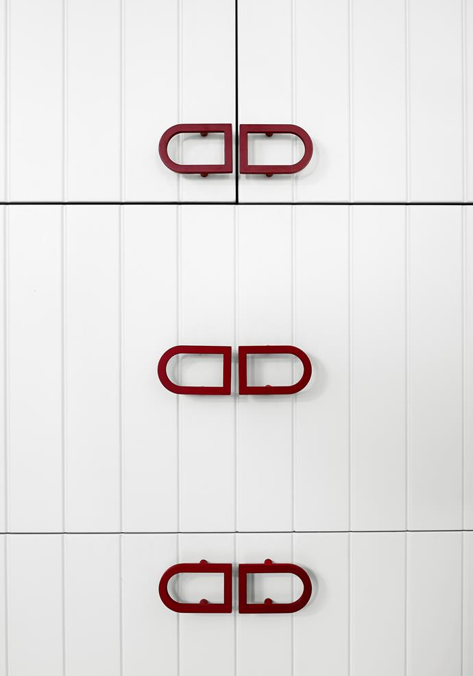 Custom red door handles provide a subtle splash of colour and personality.