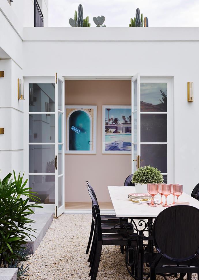 French doors create a connection with the outside while being true to the deco era. Artworks from Arthouse Co. 'Charpentier' sconces from RH Modern. Kartell 'Victoria Ghost' chairs from Space.
