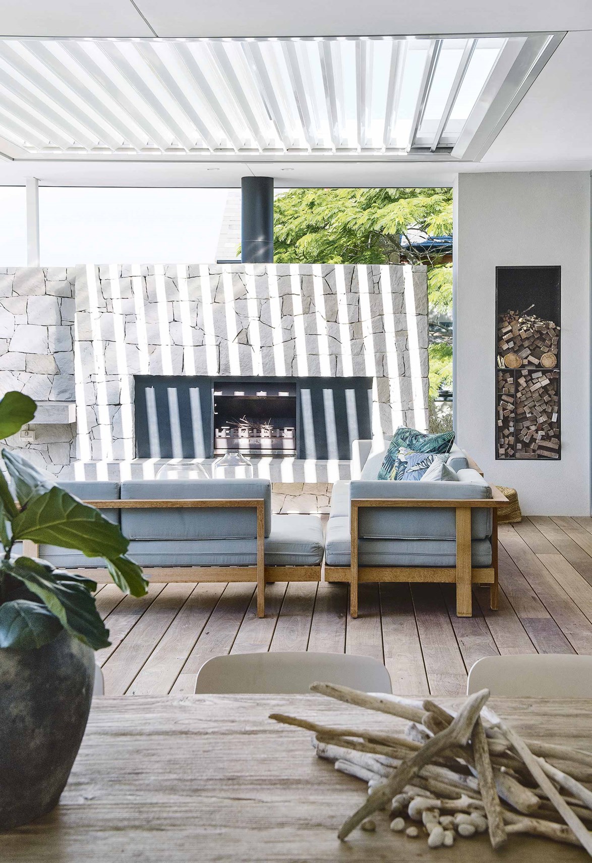 Using natural stone as a finish throughout the home is a wonderful to link indoors and outdoor spaces. Creating a visual journey in texture and tone, [this outdoor fireplace](https://www.homestolove.com.au/contemporary-eco-friendly-home-perth-17078|target="_blank") is clad in the same stone as the indoor fireplace, as well as retaining walls surrounding the pool deep in the backyard.