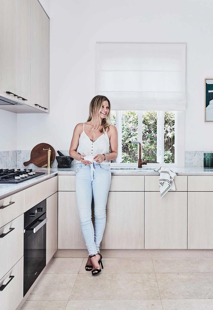 **Kitchen** Kristy leans into her limewash oak-veneer cabinetry with custom bronze-rod detailing. The benchtop is 20mm Carrara marble and the splashback is recessed Carrara finger tiles. Flooring, large-format rough-sawn limestone from [Onsite Supply & Design]https://onsitesd.com.au/). Brass pepper mill and chopping board, [The DEA Store](https://thedeastore.com/). Artwork by Maria Kostareva, through [Curatorial+Co](https://curatorialandco.com/).