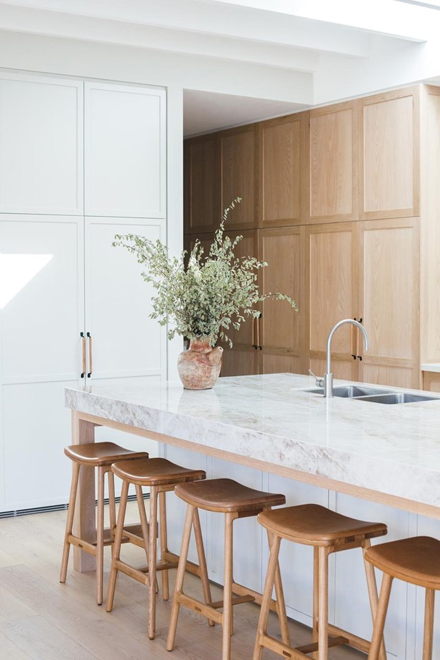 This [two-toned kitchen](https://www.homestolove.com.au/kyal-and-kara-new-home-21483|target="_blank") seamlessly blends white cabinetry with warm wooden elements to add depth and dimension without sacrificing the clean, crisp aesthetics of a traditional white kitchen. 

*Photographer: Grace Picot | Story: Real Living*