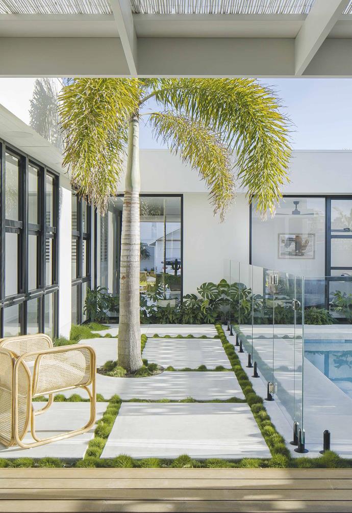 Custom-cut pavers are laid in an irregular pattern, drawing the eye around the garden, rather than imposing a single direction in the courtyard of this [Palm Springs-style home](https://www.homestolove.com.au/palm-springs-inspired-home-19646|target="_blank"). Zoysia grass panted between the pavers helps to soften the space, as does the towering palm tree.