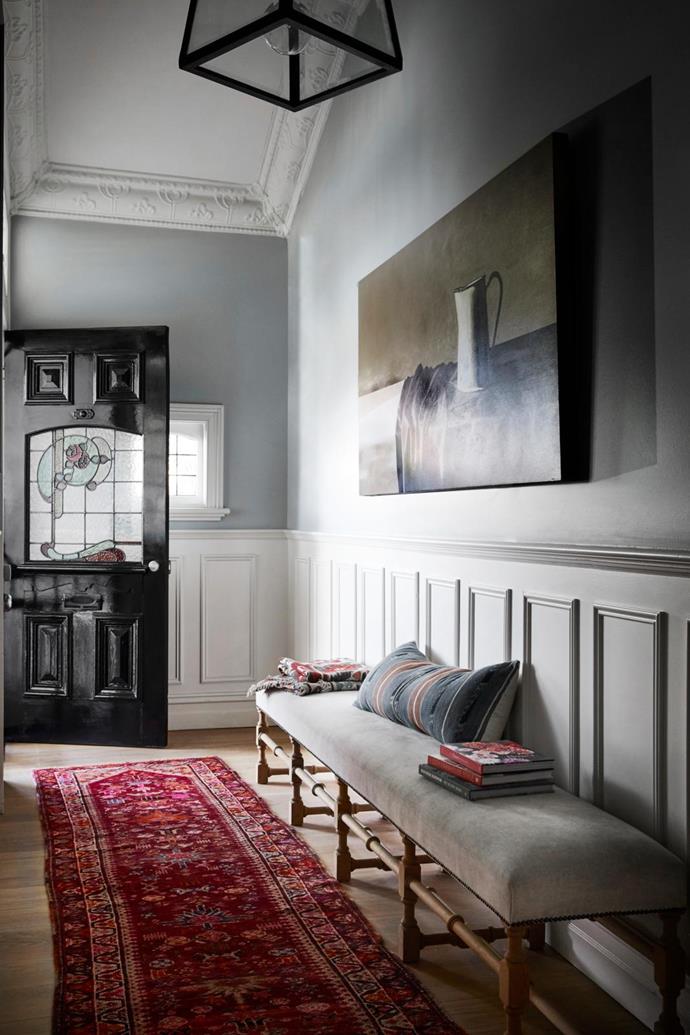 A soft grey colour above the wainscoting in the entrance hall of this [renovated Victorian weatherboard home](https://www.homestolove.com.au/renovated-white-weatherboard-home-melbourne-21530|target="_blank") gives a cloud-like air and provides a cool backdrop for dramatic art.