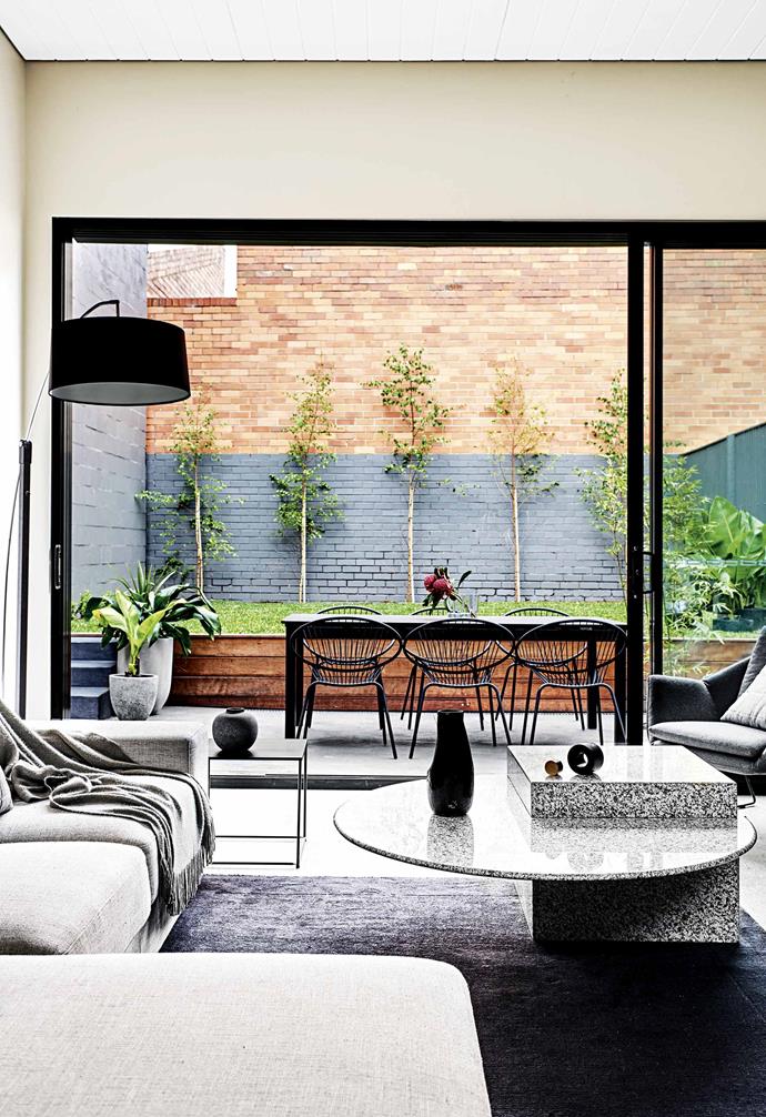 Georgie and Lu focused on powerful textural contrast for their interior design scheme. Concrete tiles, besser blocks, brick and cladding – the gentle layering effect formed the backdrop for the home's elegant styling. "We didn't compromise on any of our original plans, architectural detailing, internal specifications, appliances, fixtures or fittings," says Georgie. The pair was completely committed to following through with their vision for the home.<br><br>**Open-plan living** The connection between the rear extension and the living area is matched by cohesive styling. The [coffee table](https://www.homestolove.com.au/10-of-the-best-coffee-tables-13248|target="_blank") is from eBay while the outdoor table and chairs were found at [IKEA](https://www.ikea.com/au/en/|target="_blank"|rel="nofollow").